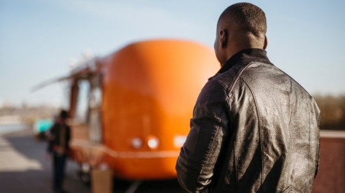 mid-shot-man-walking-towards-food-truck_23-2148757255